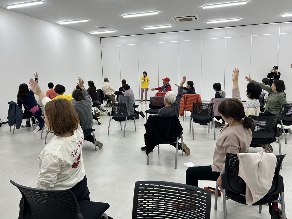 腕を上げてストレッチする参加者